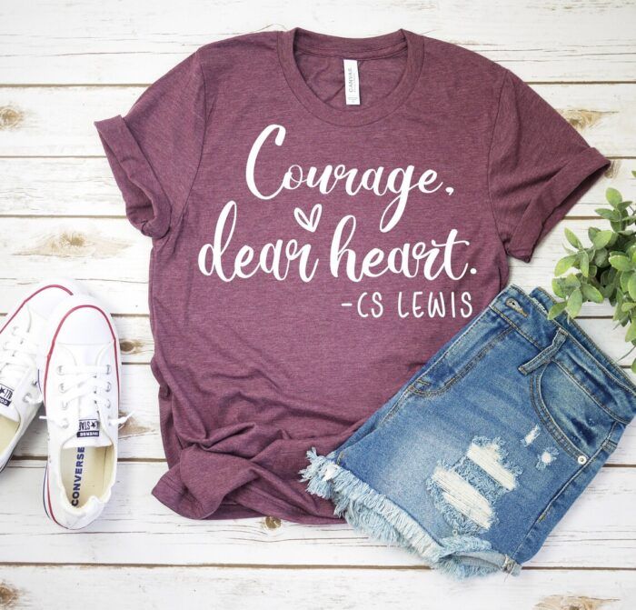 a wine-colored CS Lewis Heart T Shirt with text that reads "Courage, dear heart."