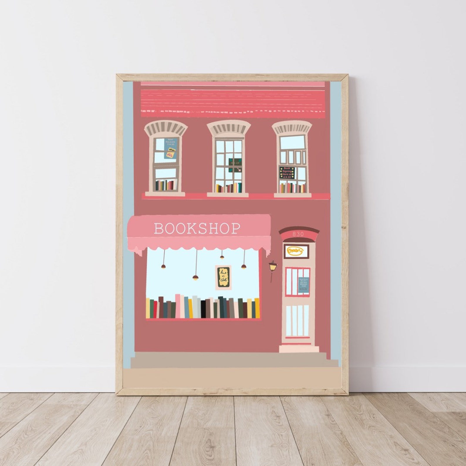 Print of a pink two story brick bookshop with glimpses of bookshelves in the windows.