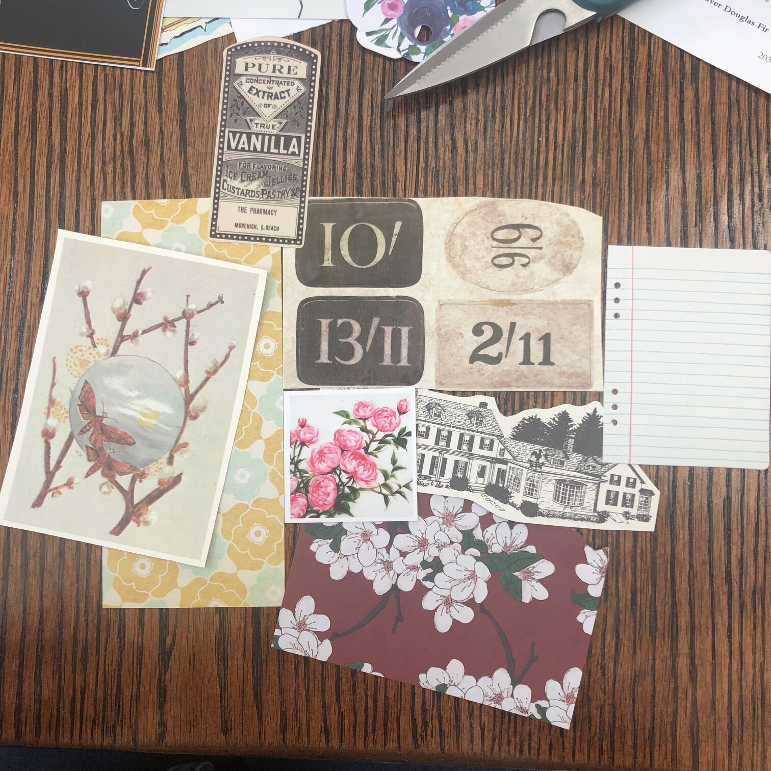 Patterned papers, a cutout of butterflies, floral stickers, and other paper paraphernalia lays on a table. 