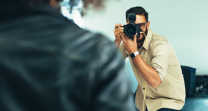 a photo of a photographer taking a picture of a person in the foreground