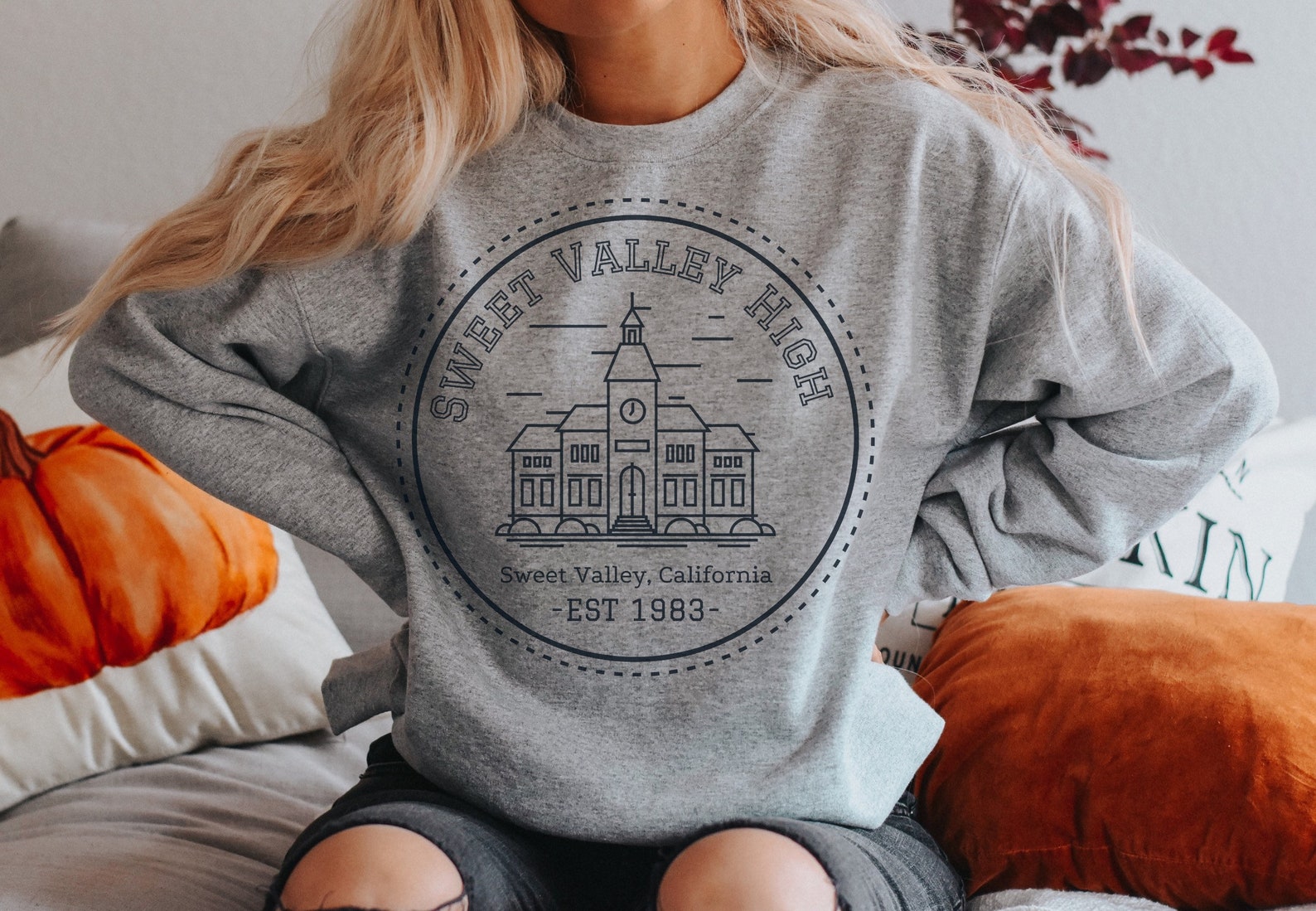 Image of a white person in a gray sweatshirt that reads "Sweet Valley High, Sweet Valley, California, Established 1983".