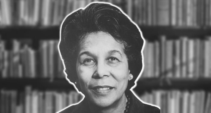 black and white image of Carol Stanton Jones against a blurred background of library stacks