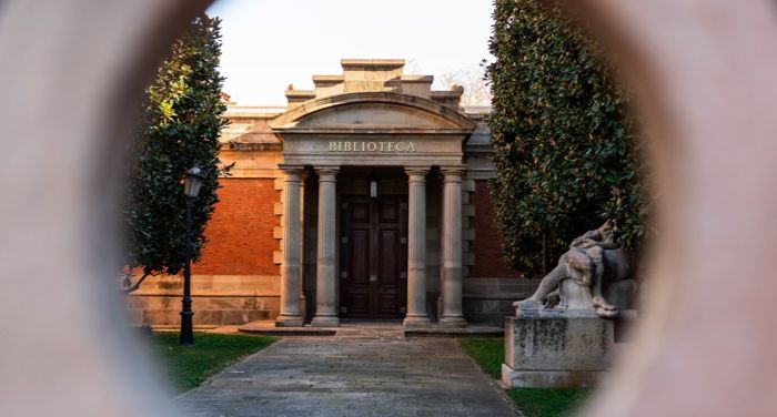 facade of a library with stone columns as seen from an outer gate