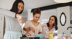 a photo of three people cooking together and laughing