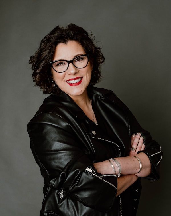 headshot of author Deanna Raybourn. She is wearing a black leather jacket and has her arms crossed.