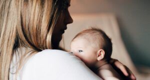 a photo of a woman with her face in shadow holding a baby