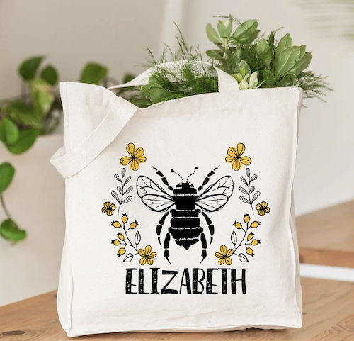 cream tote bag with printed bee and flowers that can be personalized with name