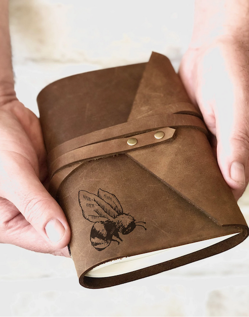 brown journal that wraps closed with an embossed black printed bee in the corner