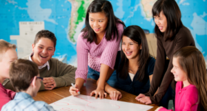 a photo of a group of middle schoolers working on a group project and laughing