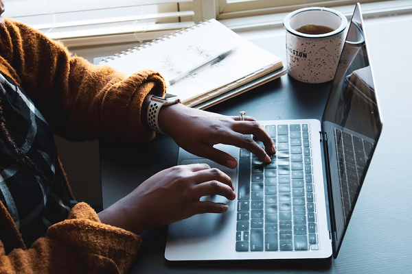  photo of someone writing on a laptop