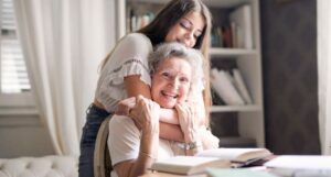 fair skinned teen and grandmother hugging