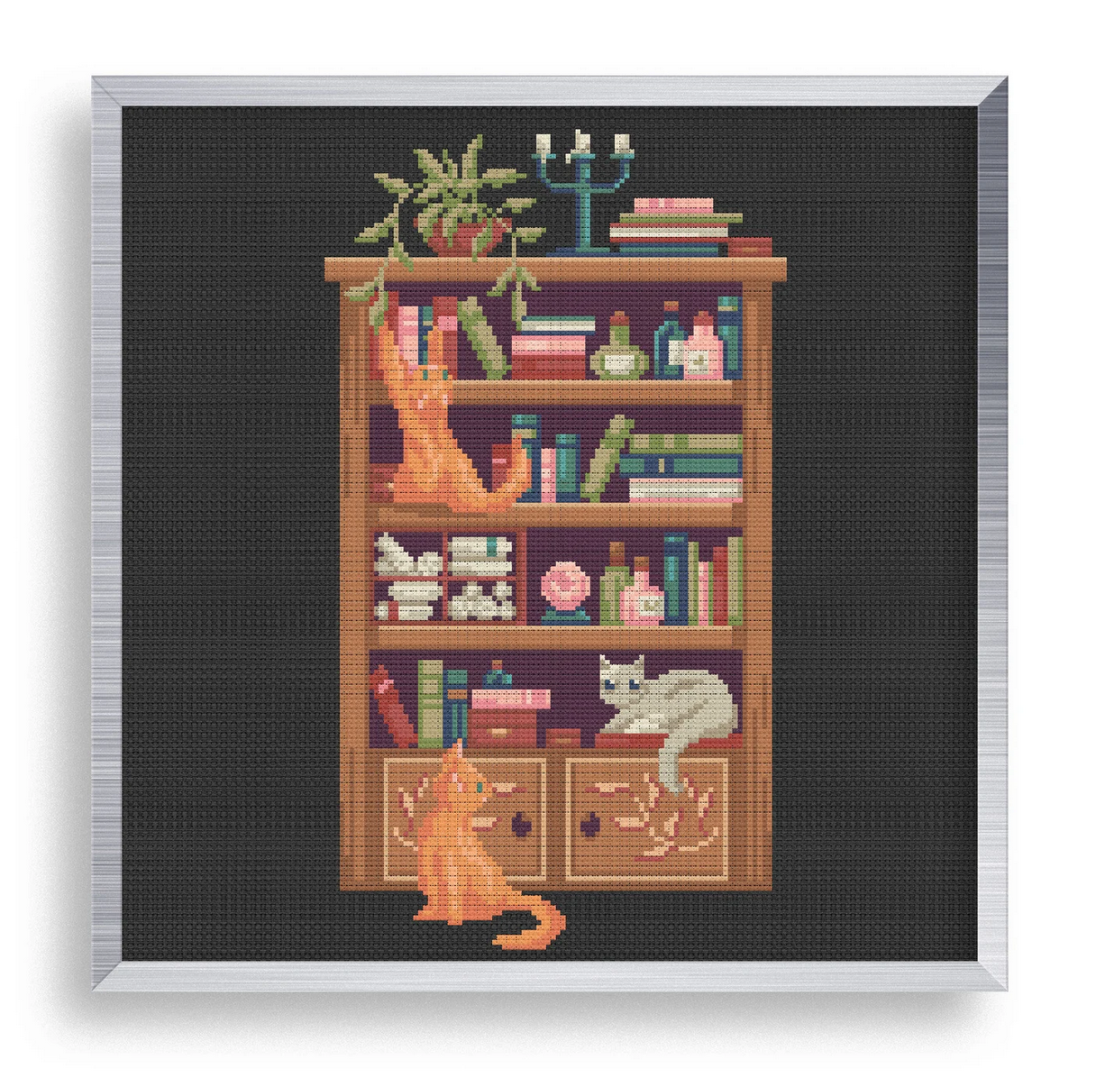 Cross stitch of cats on a bookshelf