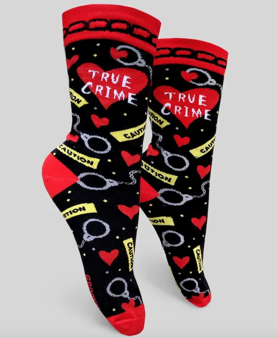 Socks with the words "True Crime" in a heart and featuring a pattern of caution tape, hearts, and handcuffs.