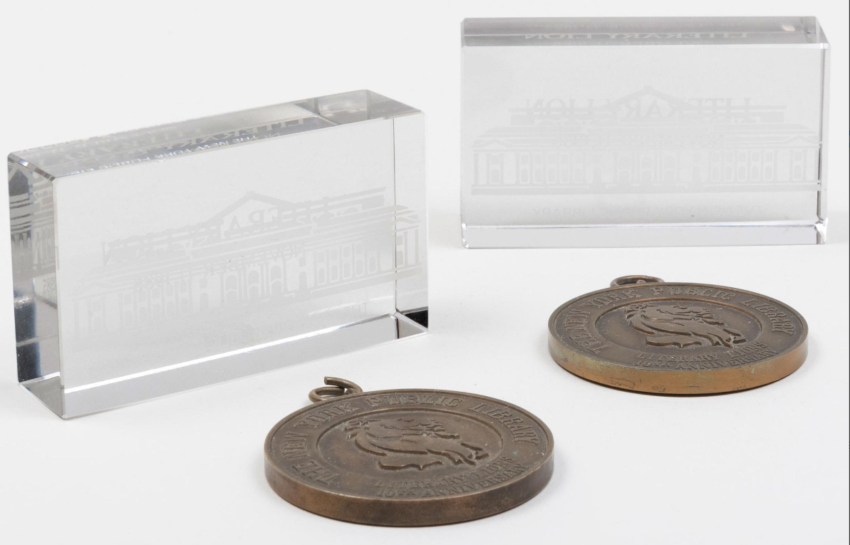 a pair of New York Public Library Literary Lions paperweights and a pair of New York Public Library Literary Lions medallions