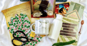 a photo of a Once Upon a Book Club book subscription box with gardening gloves, shears, a mug, and other goodies