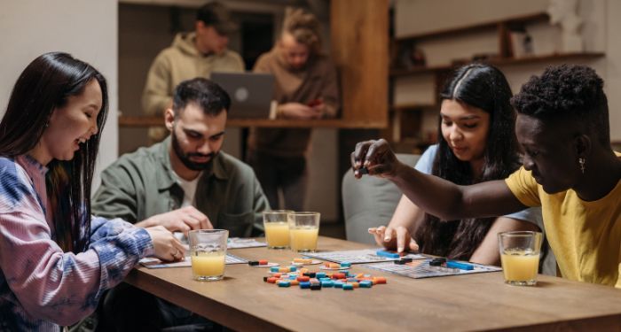 Four individuals playing a tabletop game