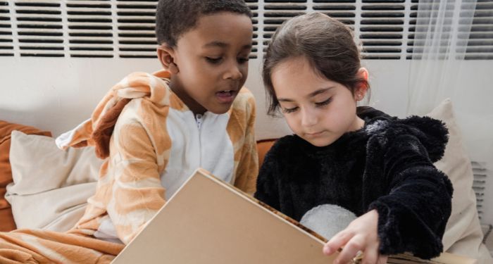 two children reading a picture book together