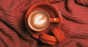 a photo of headphones and a latte on a red knitted fabric