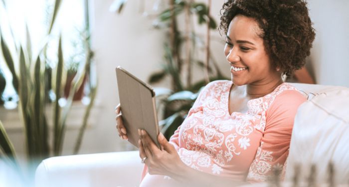 Image of a Black woman reading a tablet