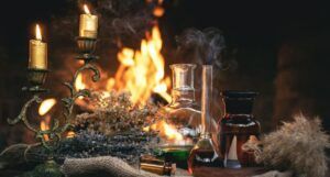 glass decanters filled with colorful liquid next to a candelabra with lit candles and a fire burning in the background