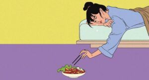 the cropped cover of I Want to Die But I Want to Eat Tteokbokki, showing an illustration of a woman lying on a bed crying as she reaches down with chopsticks towards a bowl on the ground