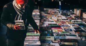 fair-skinned man shopping for used books outside