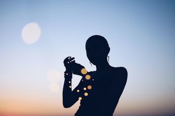 Silhouette of a person against a blue and orange sky