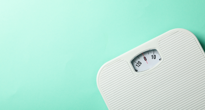 a photo of a scale against a mint green background