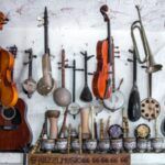 A variety of musical instruments hanging from a ceiling