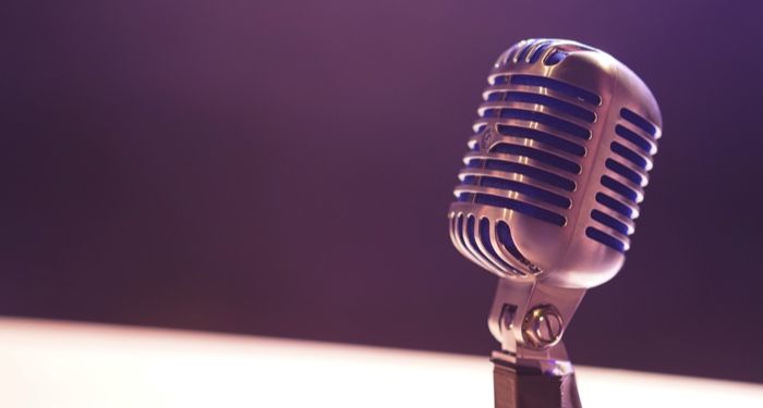 a silver condenser microphone against a dark background