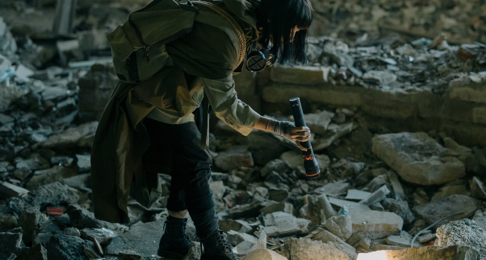 a photo of someone searching rubble with a flashlight