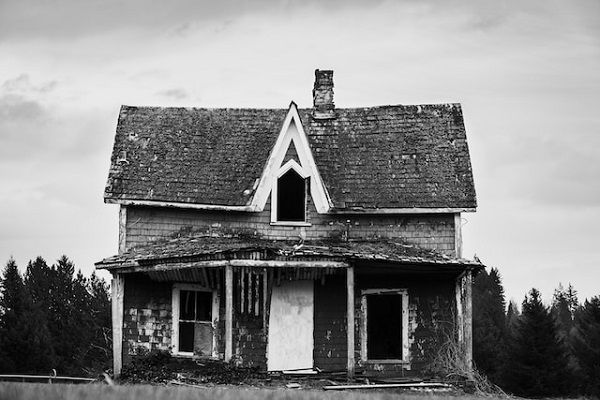 a black and white photo of a dilapidated house