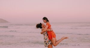 two women embracing at the edge of the sea