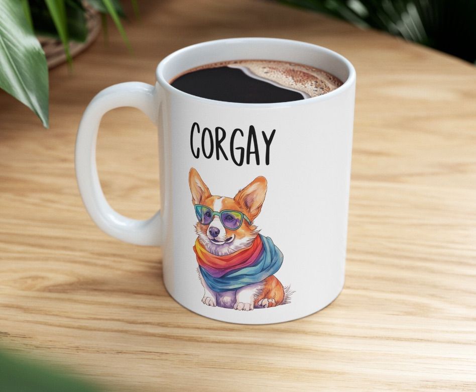 Image of a white mug with a corgi dog wearing a rainbow bandana. It says "corgay."