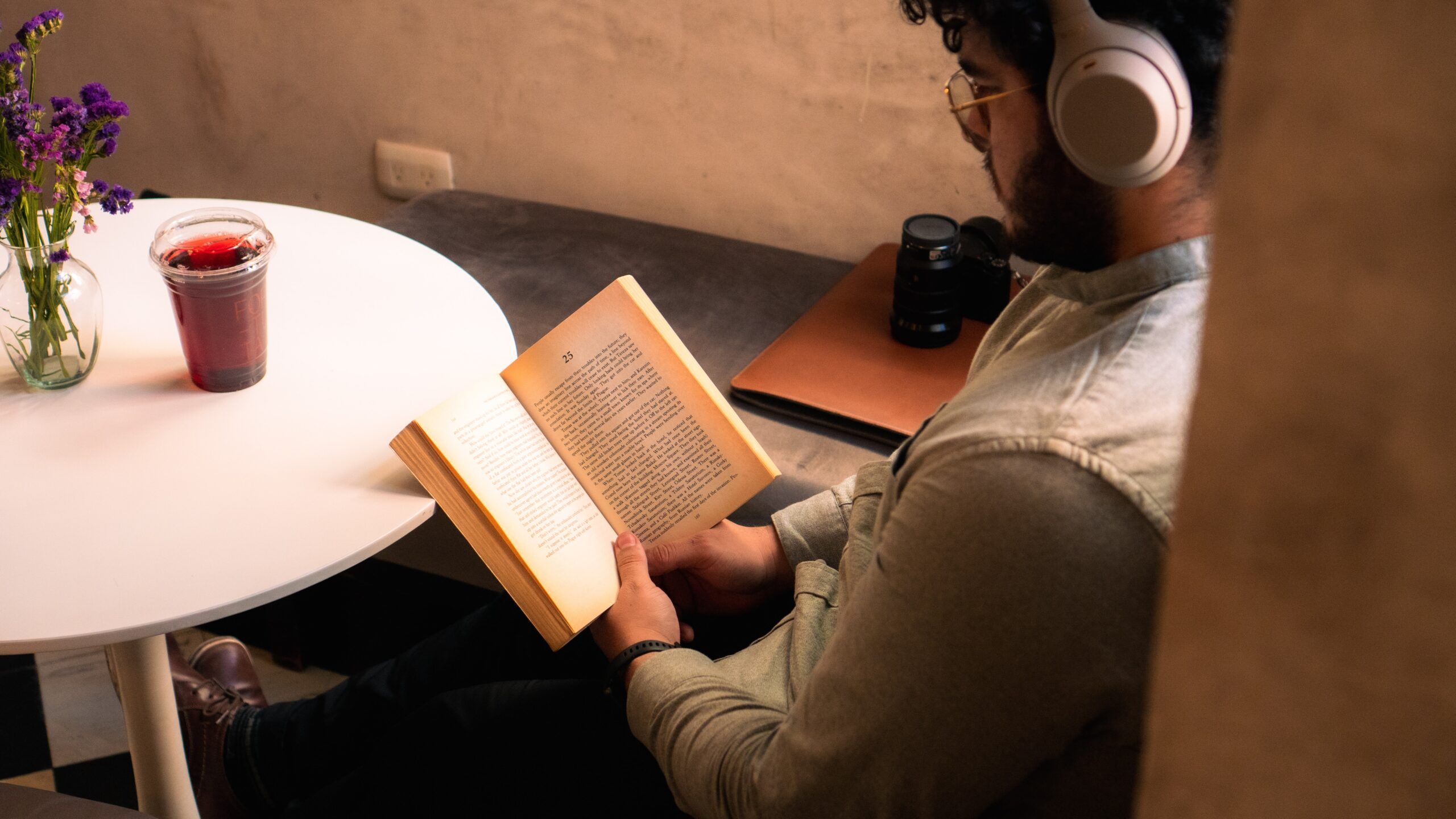 tan-skinned Latine man with beard reading in a cafe nook