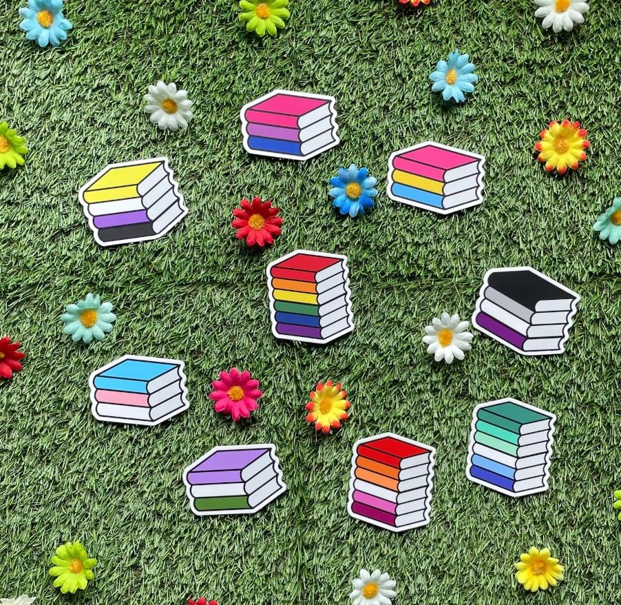 several pride flag styles designed like stacks of books. 