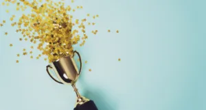 a gold trophy with gold star confetti spilling from it