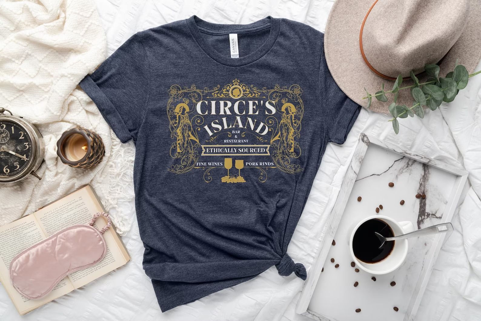 heather navy blue tshirt with text that reads "Circe's Island Bar & Restaurant. Ethically Sourced. Fine Wines, Pork Rinds"