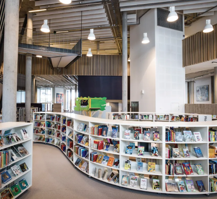 a photo of a library with curving white bookshelves