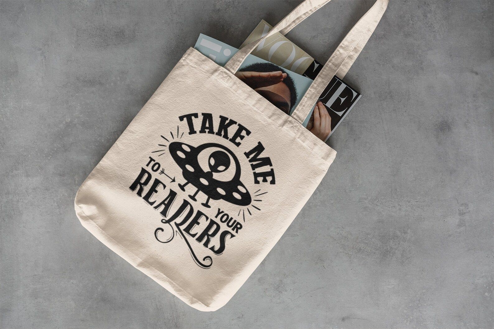 canvas tote bag with black screen print alien and words "take me to your reader."