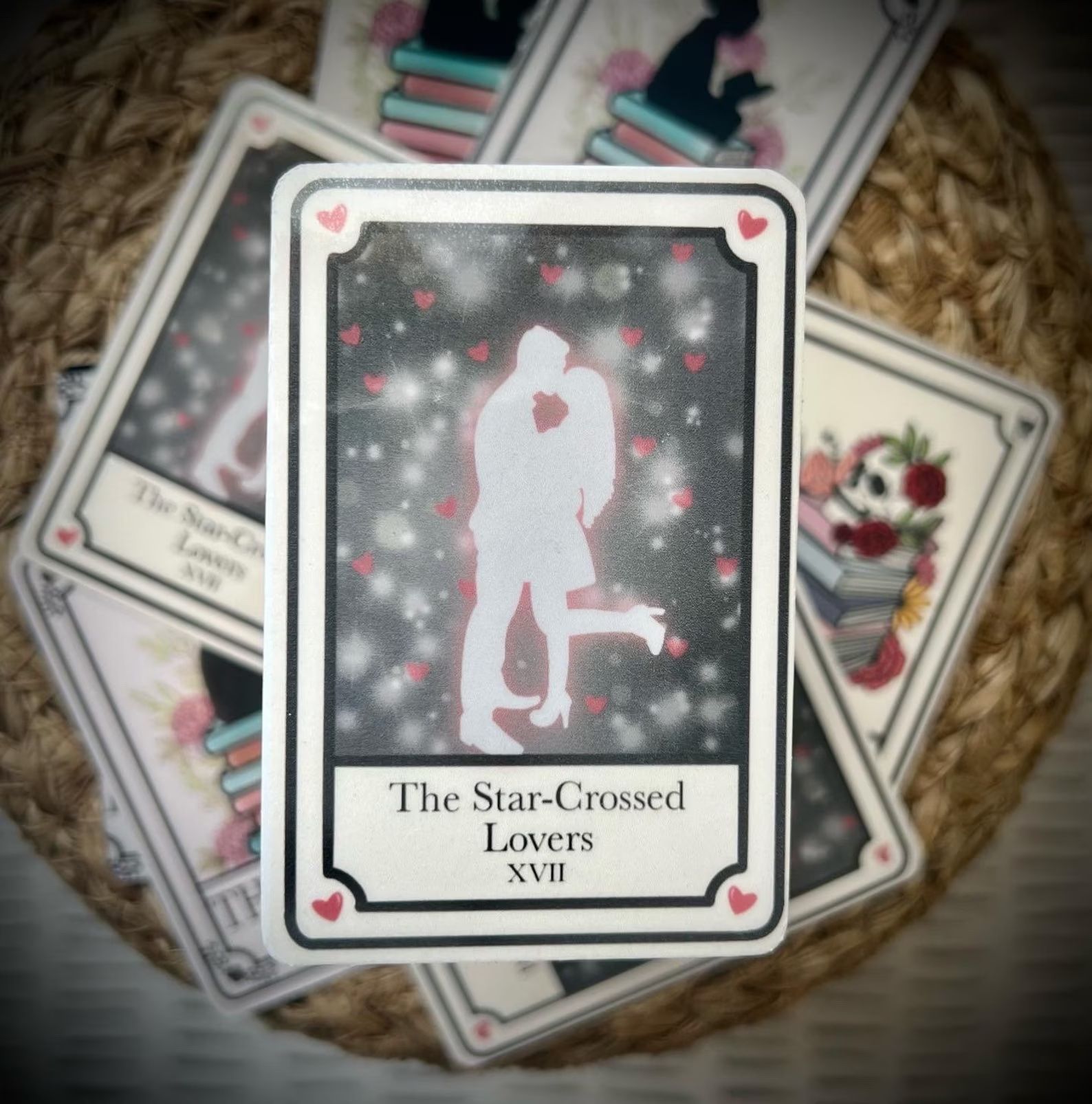 Star-Crossed Lovers Tarot Card Sticker in front of a pile of tarot card stickers.