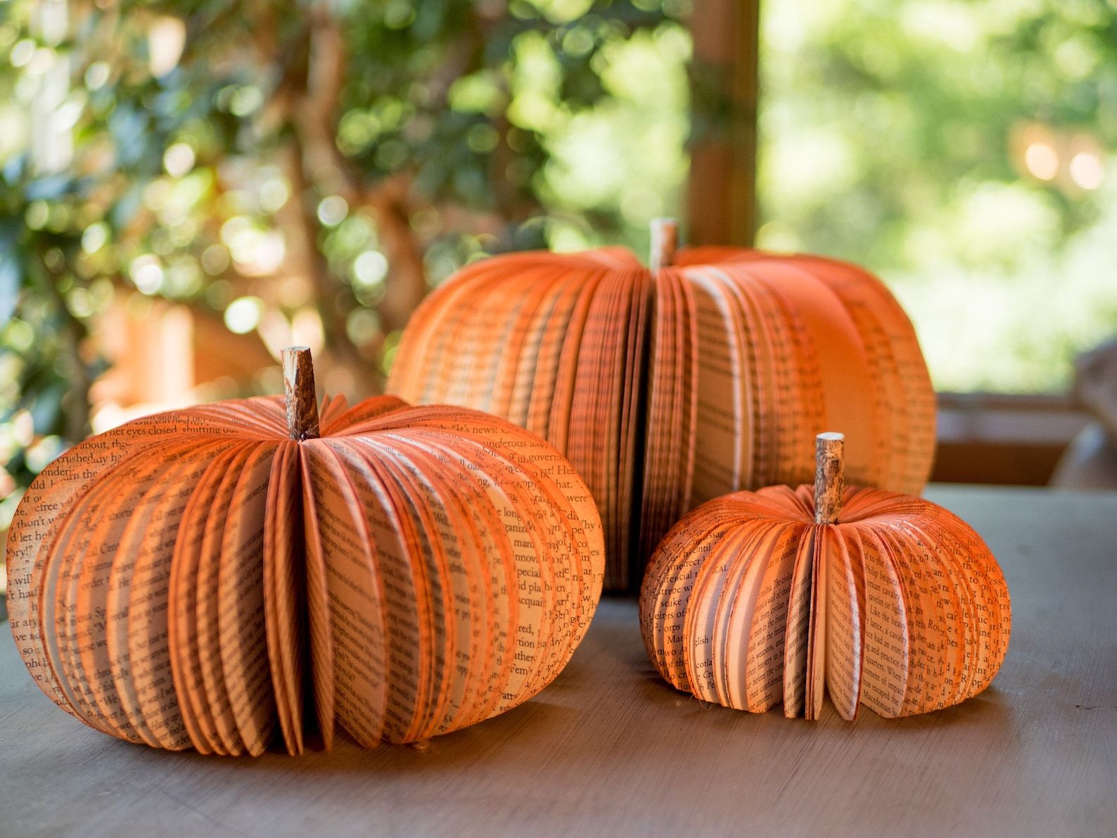 Orange pumpkin decor made out of book pages spray painted orange