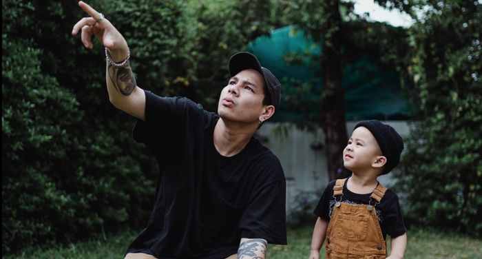 fair-skinned father of color with his son in the yard