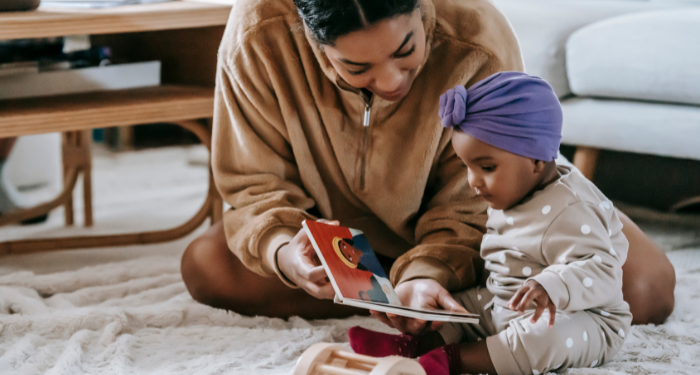 a photo of a Black mother and baby reading a board book