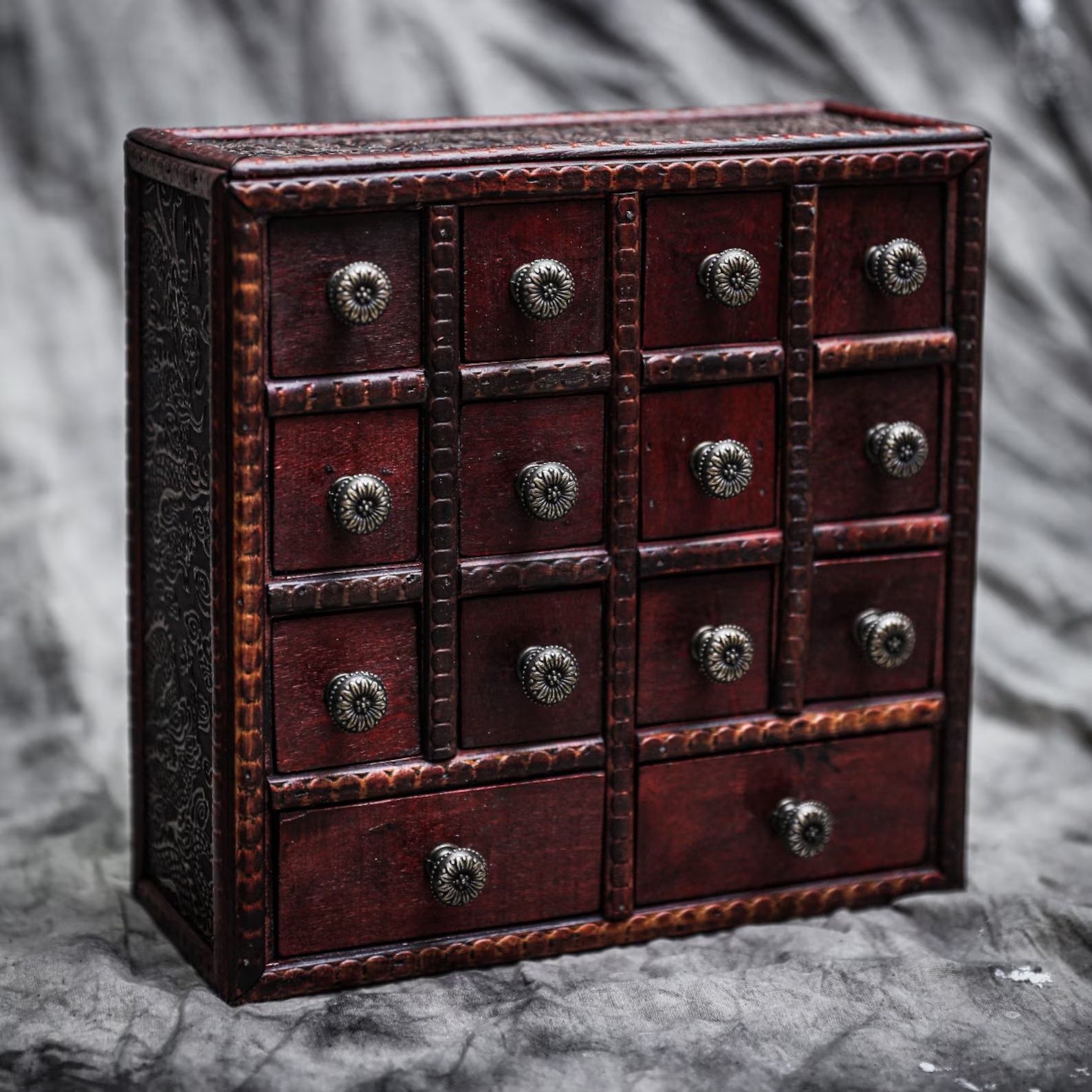 Wooden box with drawers in front of a marble backdrop.