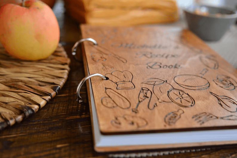 Photo of a binder with two rings and images and text engraved