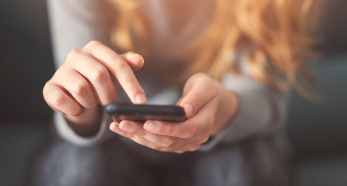 a photo of someone scrolling through their phone, just their hands in focus