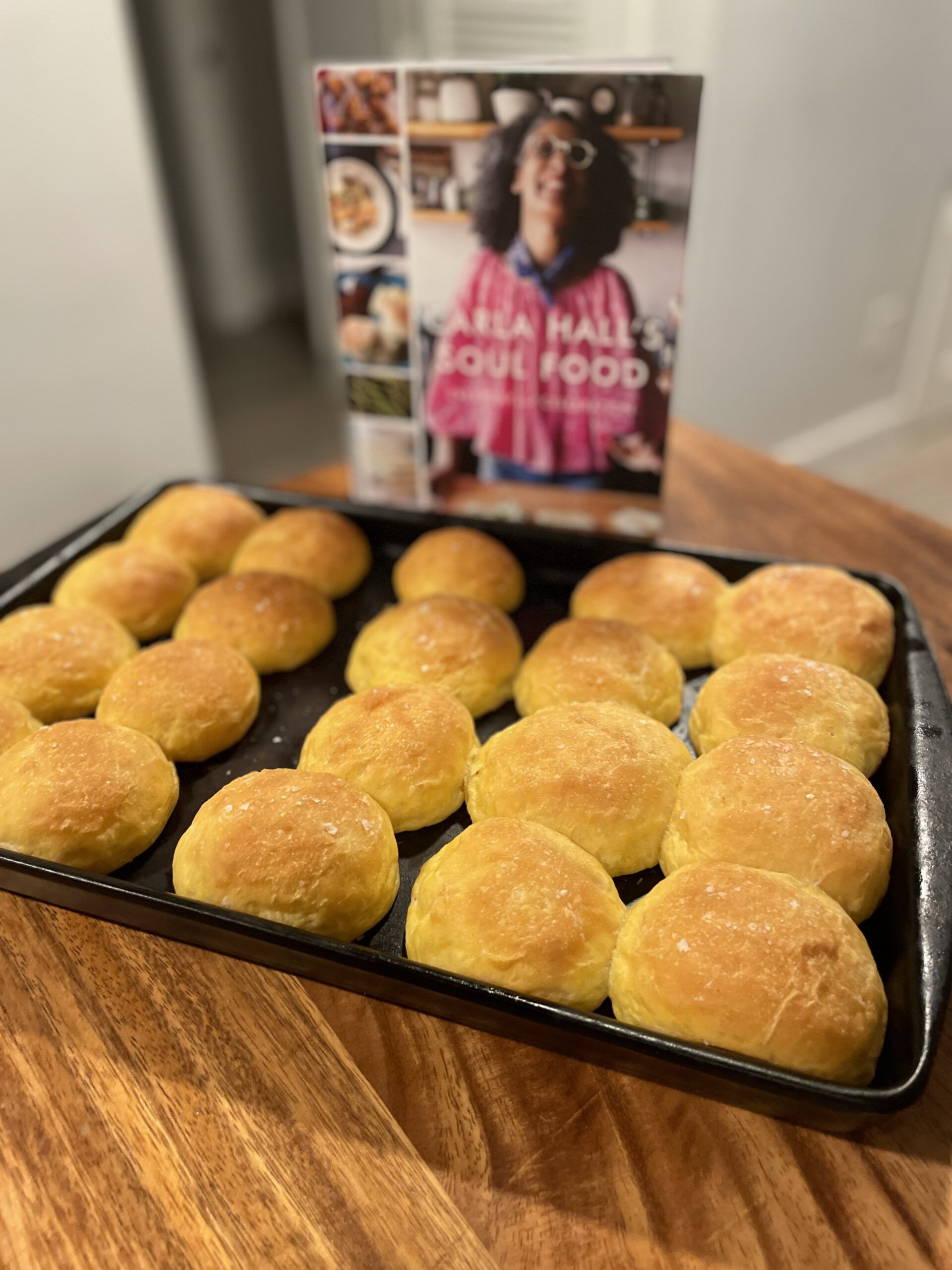 A ban of lightly orange rolls in front of the cookbook Carla Hall's Soul Food