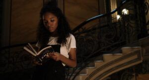 brown-skinned Black woman reading on a staircase