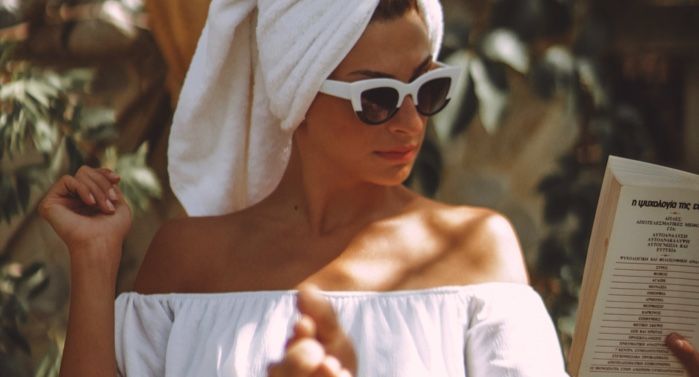 white woman dressed in spa garments and reading a book